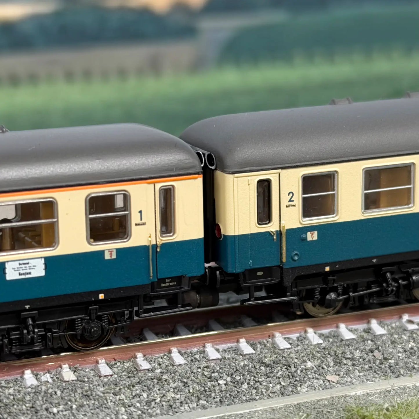 Gummiwulste berühren sich zwischen einem Minitrix ABm Wagen und einem Bm Wagen in o/b ozeanblau Beige.